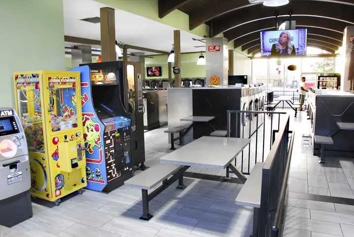 Arcade games and seating inside Rio Laundromat