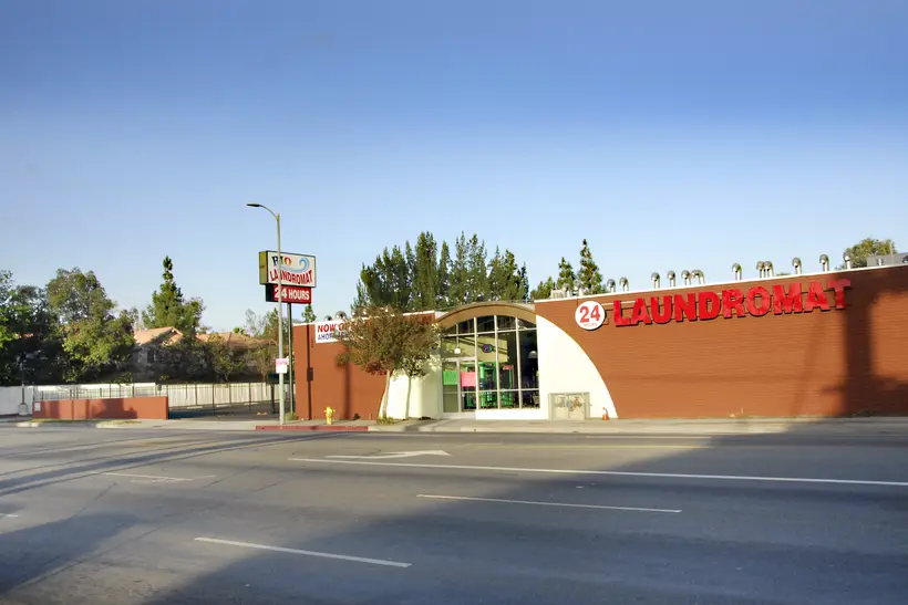 The laundromat's arched entrance on De Soto Ave at sunset